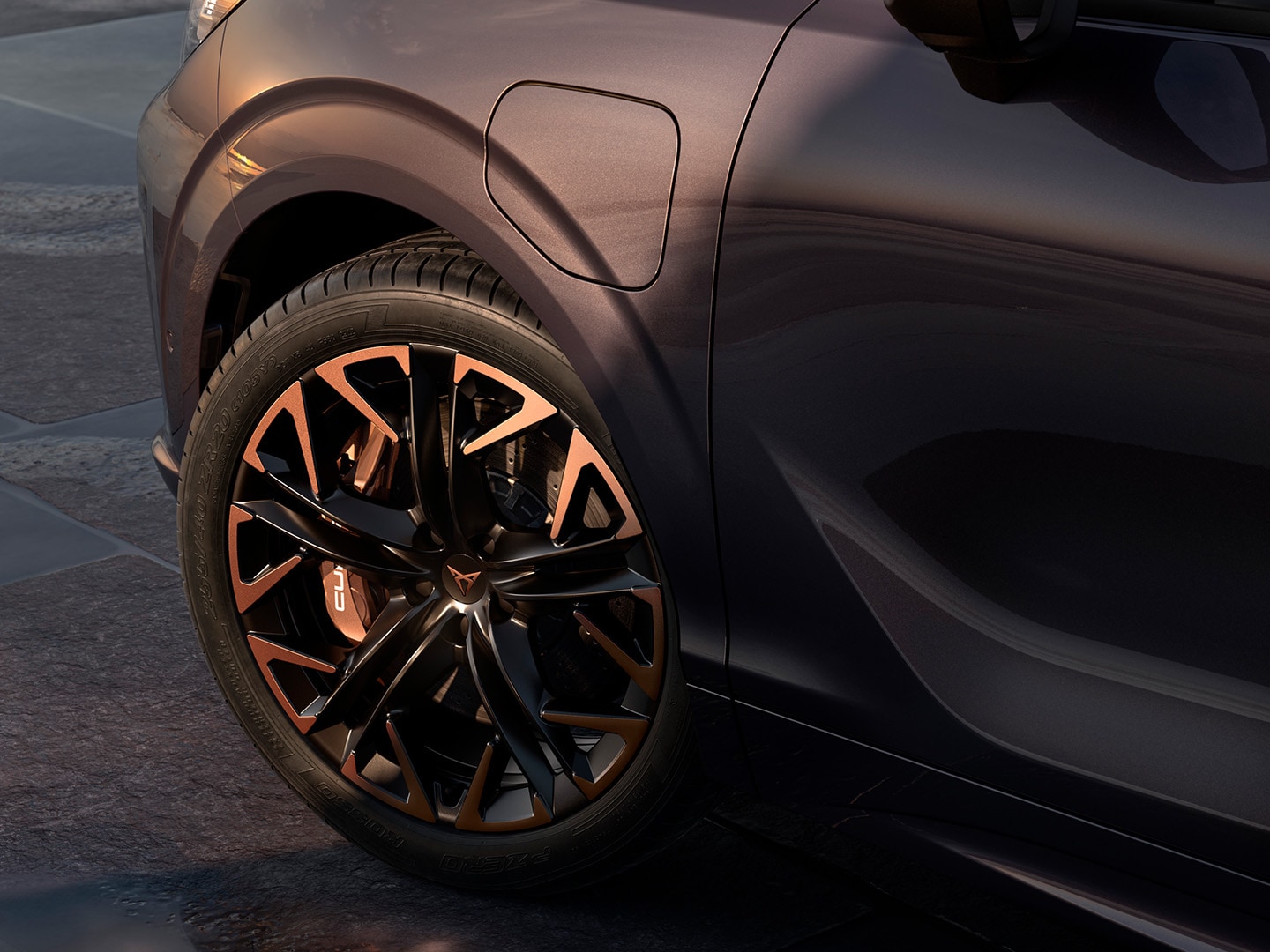 side view of CUPRA Terramar with maximum braking power, parked by the coast, highlighting the dark void paint and its 20” Hadron Copper alloy wheels.